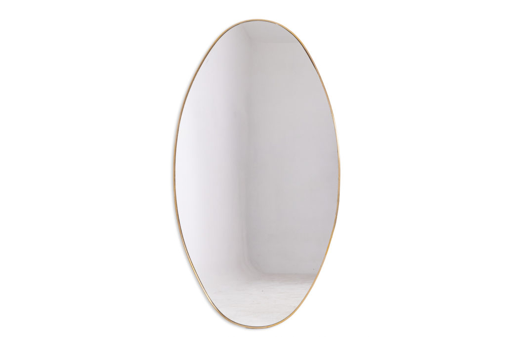 Oval-shaped mirror set with a gilded brass. 1970s.